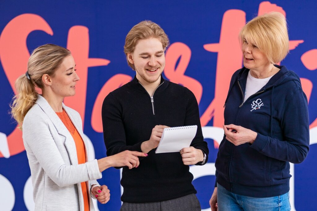 Kolme henkilöä keskustelemassa vierekkäin.