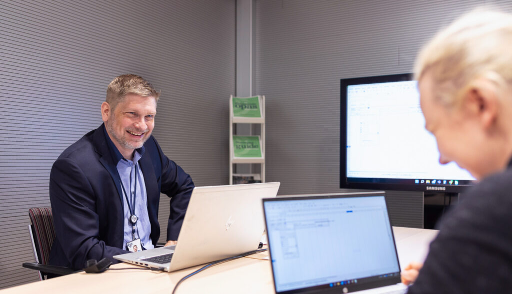 Yritysasiantuntija keskustelemassa yrittäjän kanssa kokoushuoneessa.